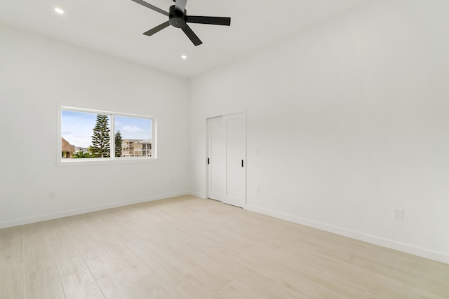 spare room featuring ceiling fan, light wood finished floors, recessed lighting, and baseboards