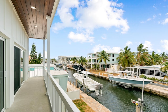 balcony featuring a water view, a dock, and boat lift