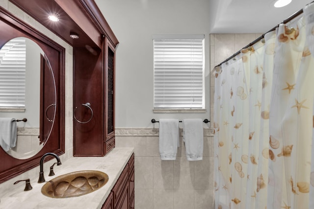 bathroom featuring vanity and tile walls