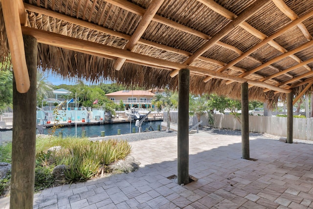 view of patio with a water view and a boat dock