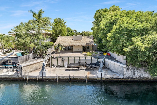 view of dock with fence private yard, a water view, a patio, and stairway