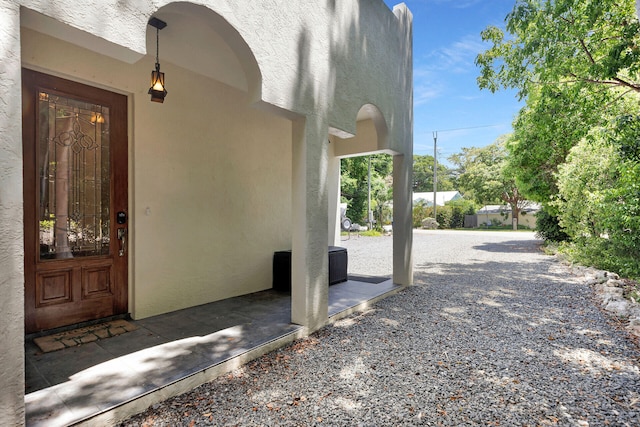 doorway to property featuring stucco siding