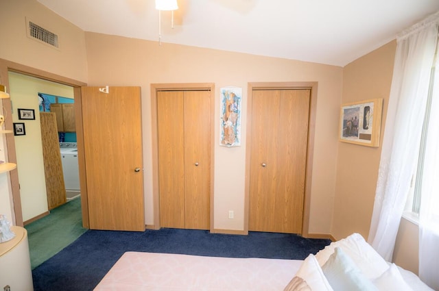 carpeted bedroom featuring multiple closets, ceiling fan, and washer / clothes dryer