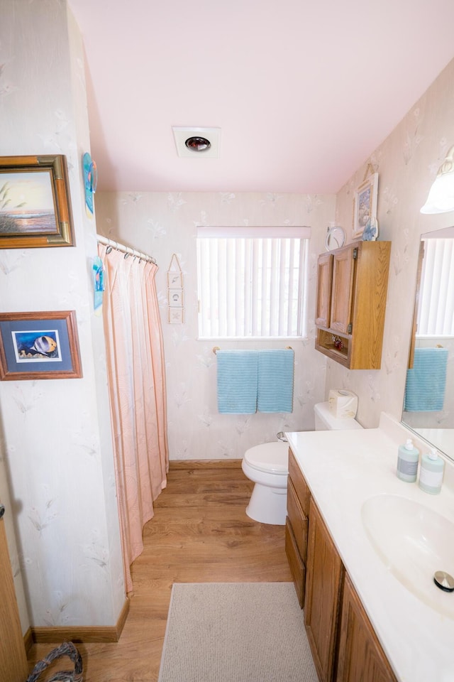 bathroom featuring wood-type flooring, vanity, and toilet