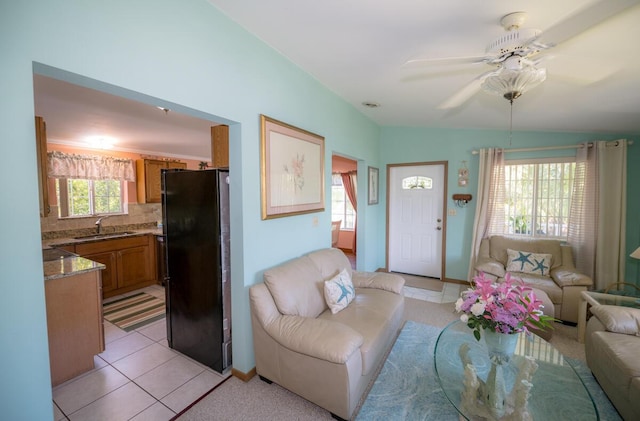 living room with sink, light tile patterned floors, and ceiling fan