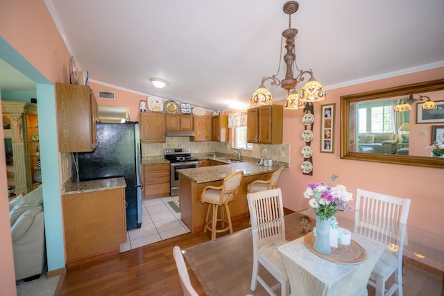 dining area featuring crown molding, plenty of natural light, vaulted ceiling, and light wood-type flooring