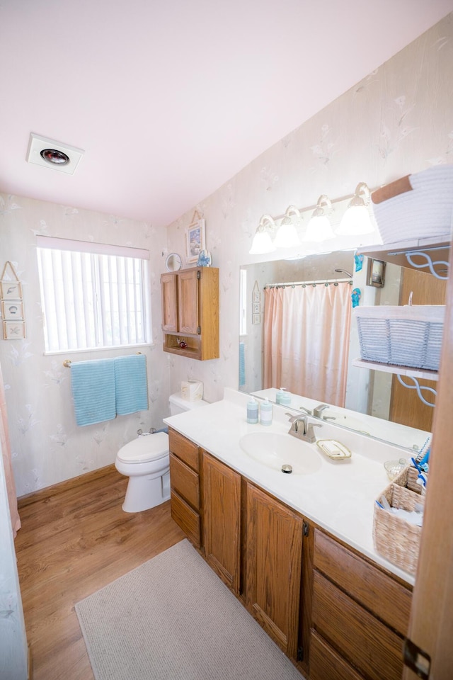 bathroom with walk in shower, vanity, toilet, and hardwood / wood-style floors