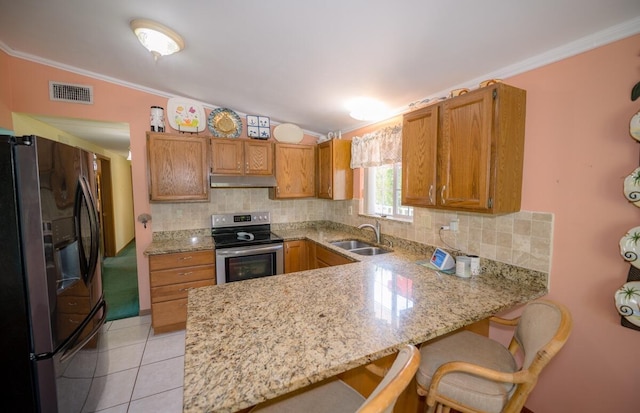 kitchen with sink, a breakfast bar area, appliances with stainless steel finishes, ornamental molding, and kitchen peninsula