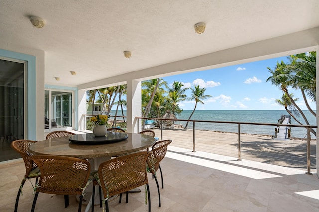 view of patio featuring a beach view and a water view