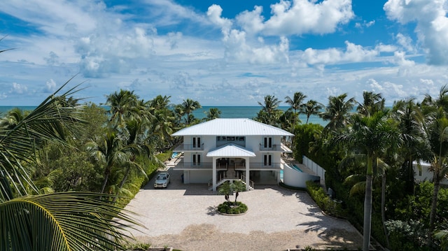 view of front of house with a carport, a balcony, a water view, and a garage