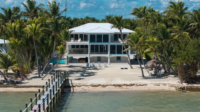 rear view of house with a water view, a balcony, and a patio area