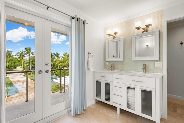 bathroom with tasteful backsplash, crown molding, vanity, and french doors