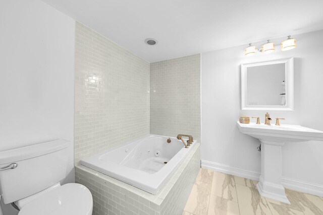 bathroom with toilet and tiled bath