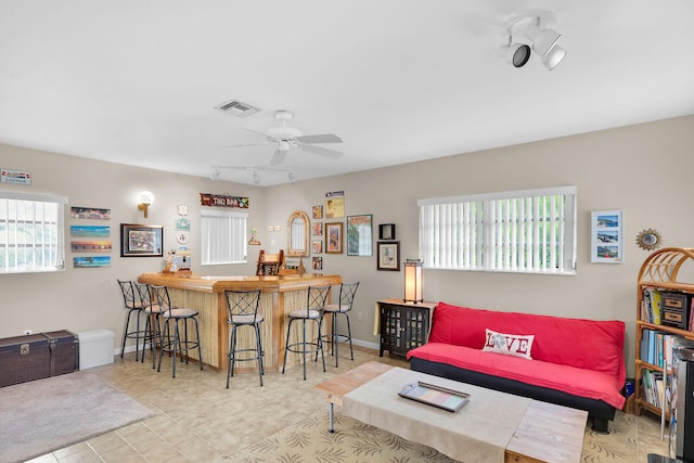 living room featuring bar, a wealth of natural light, ceiling fan, and track lighting