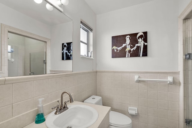 bathroom with walk in shower, vanity, toilet, and tile walls