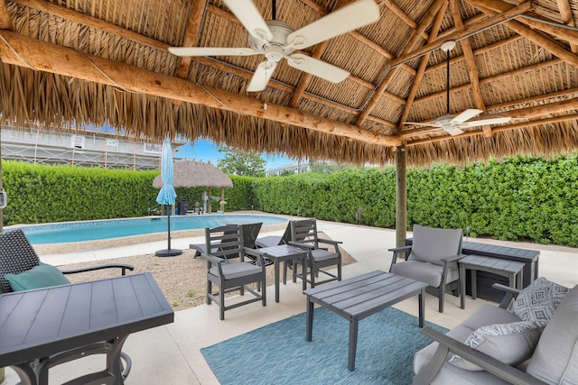 view of patio featuring a gazebo, ceiling fan, and a fenced in pool