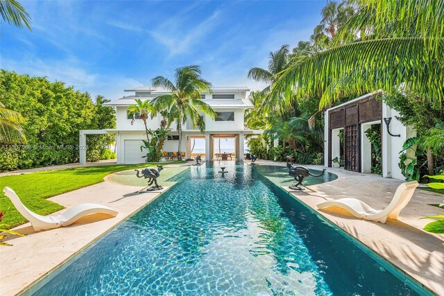 pool with a patio area and a lawn