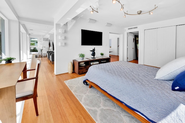 bedroom with light wood finished floors and visible vents