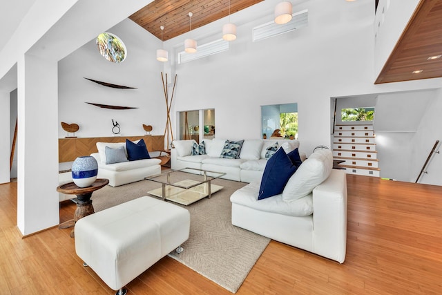 living area featuring wood finished floors, a towering ceiling, and wooden ceiling