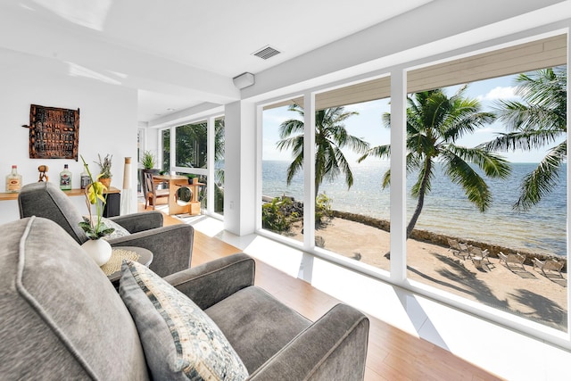 sunroom featuring a water view