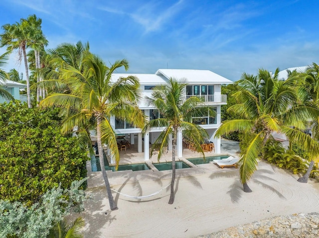 view of property's community with a jacuzzi, a patio, a swimming pool, and stairs