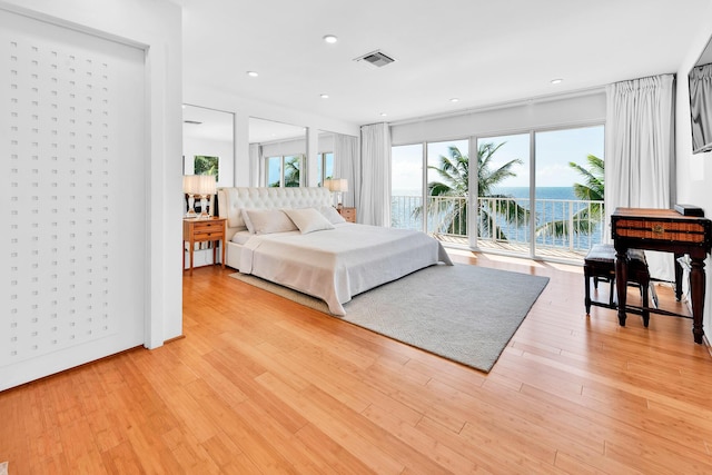 bedroom featuring access to exterior and light wood-type flooring