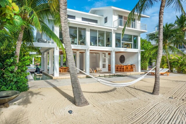 back of house with a bar, a balcony, and a patio area