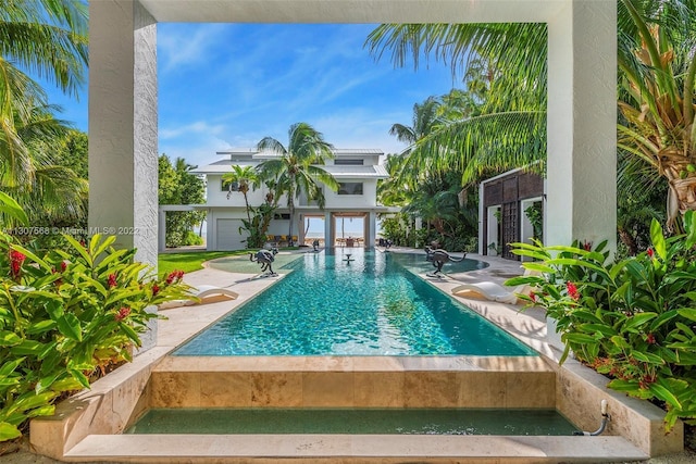 outdoor pool featuring a hot tub and a patio