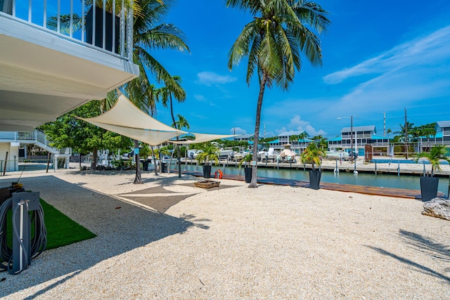 view of dock featuring an outdoor fire pit and a water view