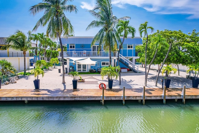 rear view of house featuring a water view and a balcony