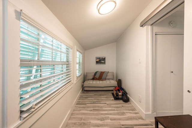 hallway featuring lofted ceiling and light hardwood / wood-style floors