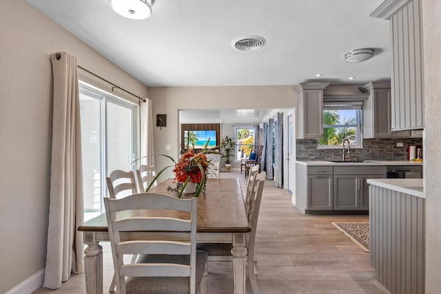 dining space with sink and light hardwood / wood-style floors