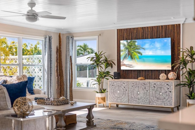 living area featuring hardwood / wood-style flooring, ornamental molding, and ceiling fan