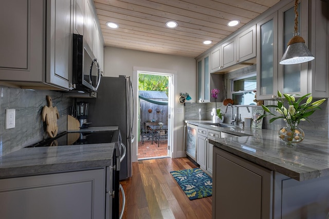 kitchen with gray cabinets, appliances with stainless steel finishes, dark hardwood / wood-style floors, sink, and decorative backsplash