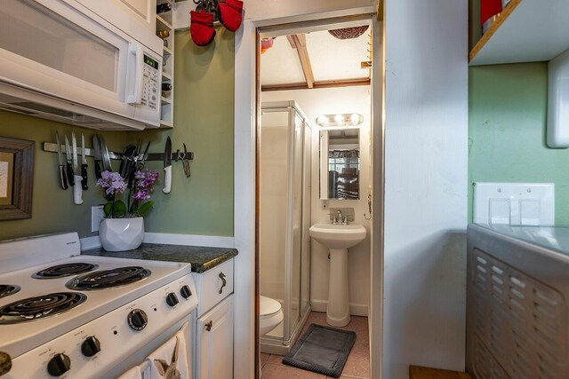 kitchen featuring light tile patterned flooring, sink, white cabinets, and white appliances