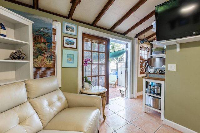 living area with lofted ceiling with beams and light tile patterned floors