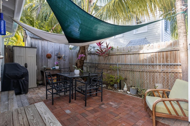 view of patio / terrace with grilling area and a storage unit