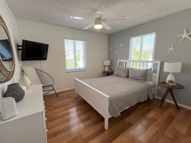 bedroom featuring multiple windows, dark wood-type flooring, and a textured ceiling