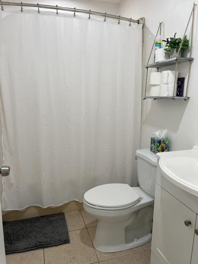 bathroom featuring vanity, tile patterned floors, and toilet