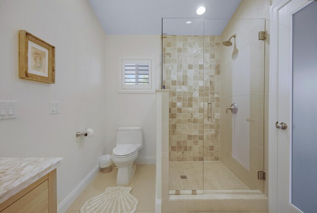 bathroom featuring vanity, tile patterned flooring, a shower with shower door, and toilet