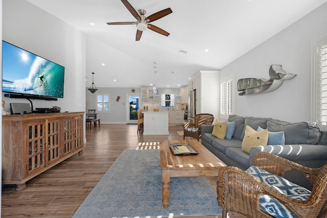 living room featuring lofted ceiling, dark hardwood / wood-style floors, and ceiling fan