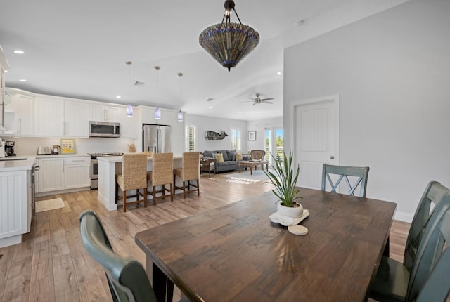 dining area featuring ceiling fan, sink, and light hardwood / wood-style floors