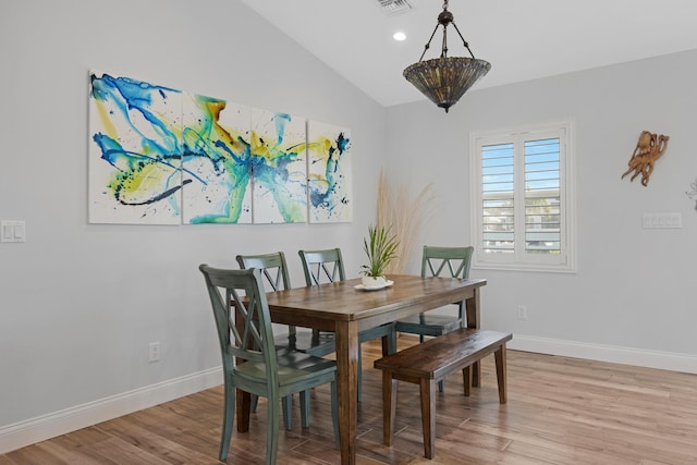 dining space with light hardwood / wood-style flooring and vaulted ceiling