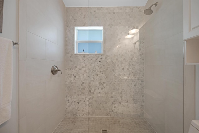 bathroom featuring toilet and tiled shower