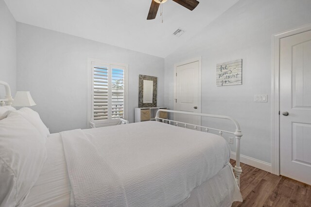 bedroom featuring ceiling fan, dark hardwood / wood-style floors, and vaulted ceiling