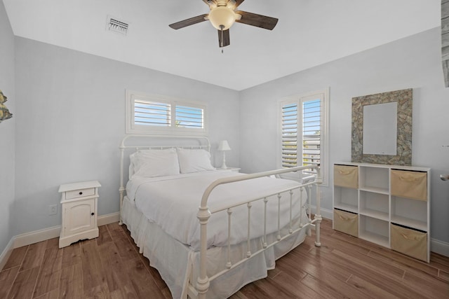 bedroom with ceiling fan, hardwood / wood-style floors, and multiple windows