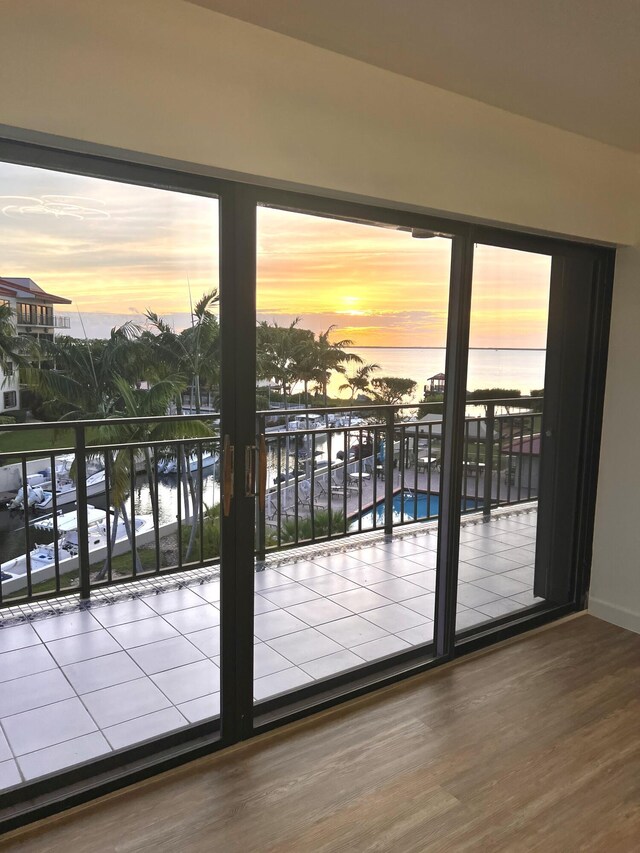 doorway to outside with hardwood / wood-style floors, a water view, and a wealth of natural light