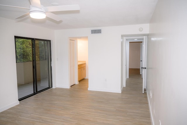 empty room with ceiling fan and light wood-type flooring