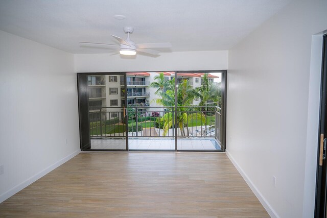 spare room with ceiling fan and light wood-type flooring