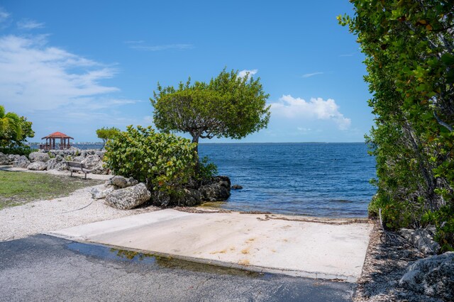 property view of water featuring a view of the beach and a gazebo